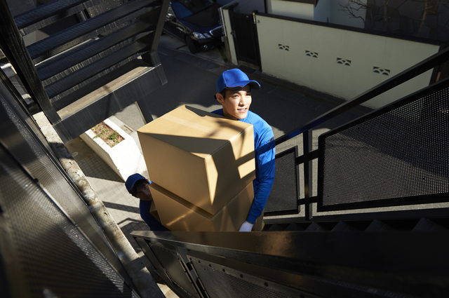 2階から婚礼タンスを搬出する作業