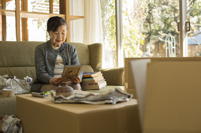 終活の断捨離で持ち物を整理するシニア女性