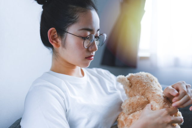 ぬいぐるみを手放すことに迷っている女性