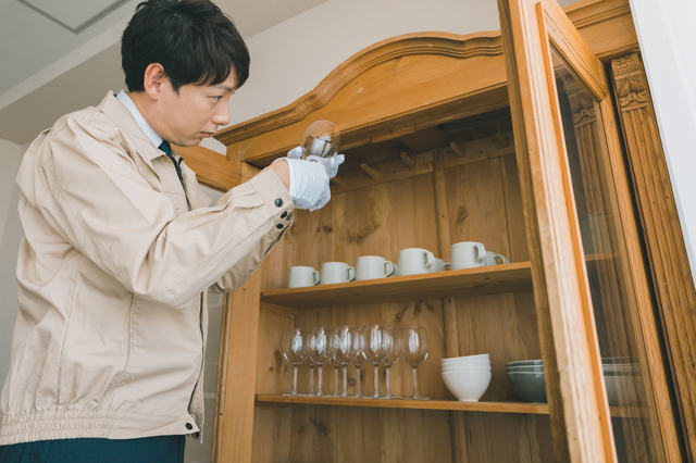 食器の裏面のブランド刻印を確認している買取査定の様子