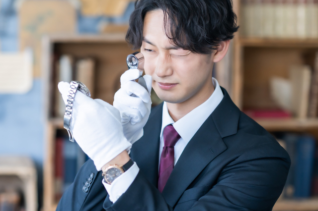 使用感のある品物を査定している買取スタッフ