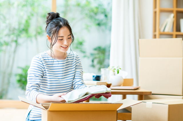 買取で値段がつかなかった子供服を寄付用に梱包するシーン