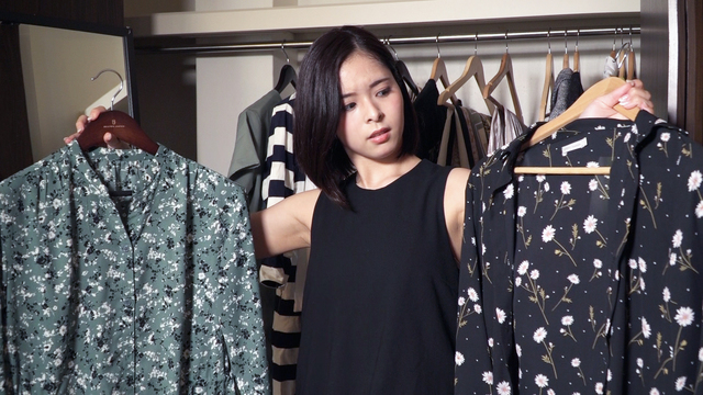 衣替えで服が捨てられず悩んでいる女性