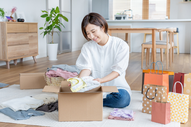サイズアウトした子供服を段ボールに詰めて寄付準備をする様子