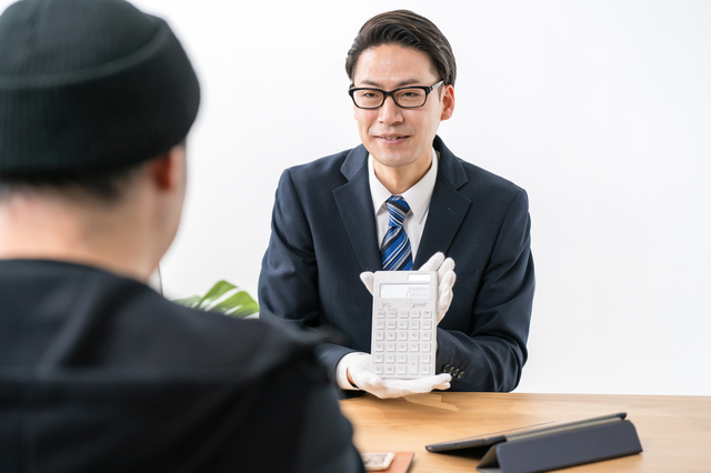 大量処分の現場で買取額を提示するウレルヤの査定員