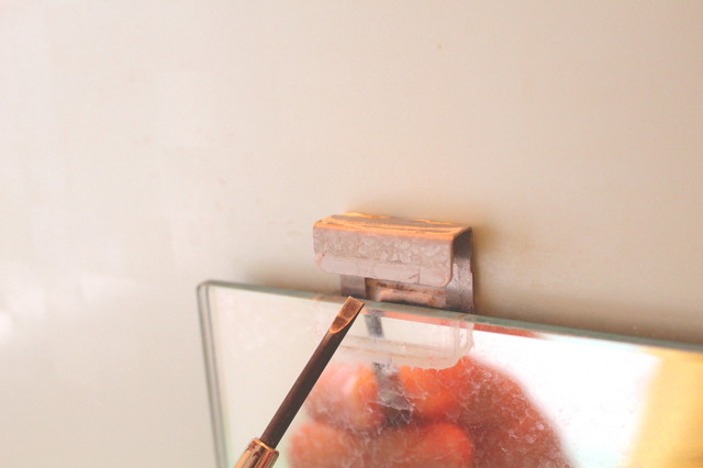 壁付けの鏡を取り外す作業の様子