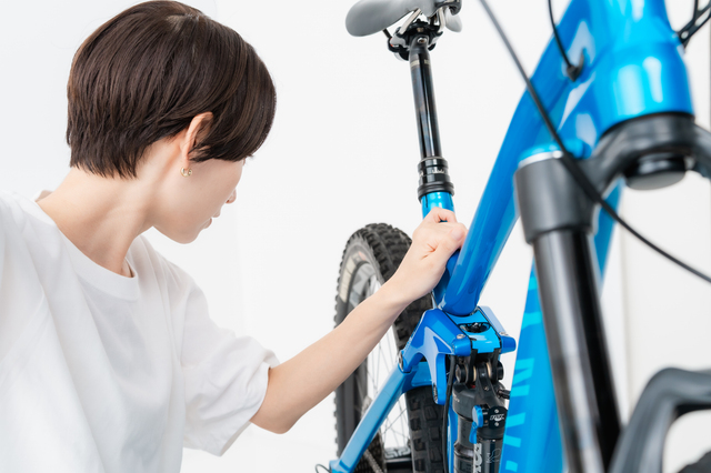 マウンテンバイクのフレームに出たサビを査定員が確認している様子